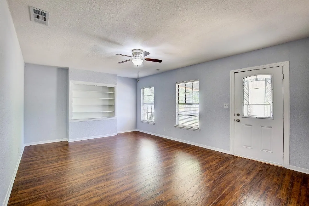 Entrance foyer with a textured ceiling, dark hardwood / wood-style flooring, and ceiling fan