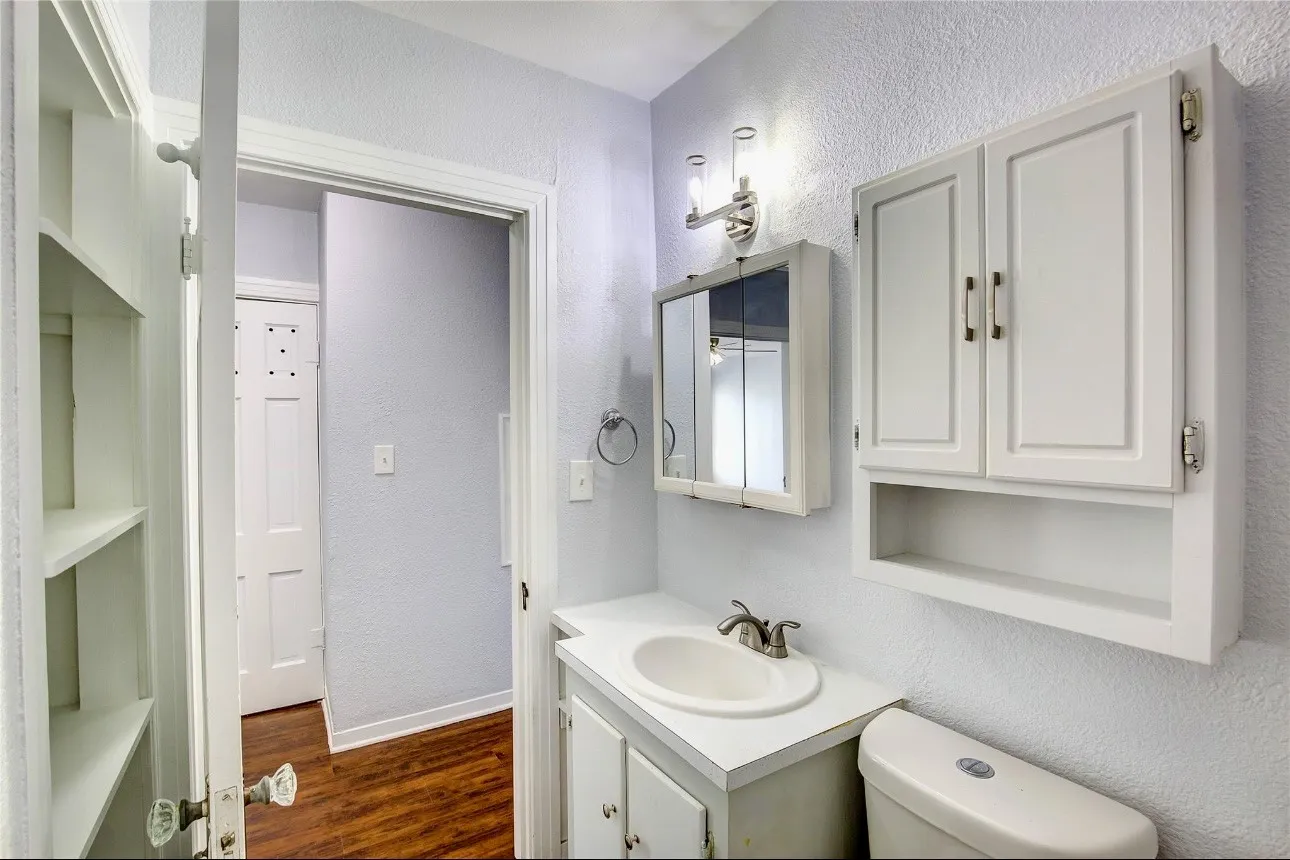 Bathroom with hardwood / wood-style floors, vanity, and toilet