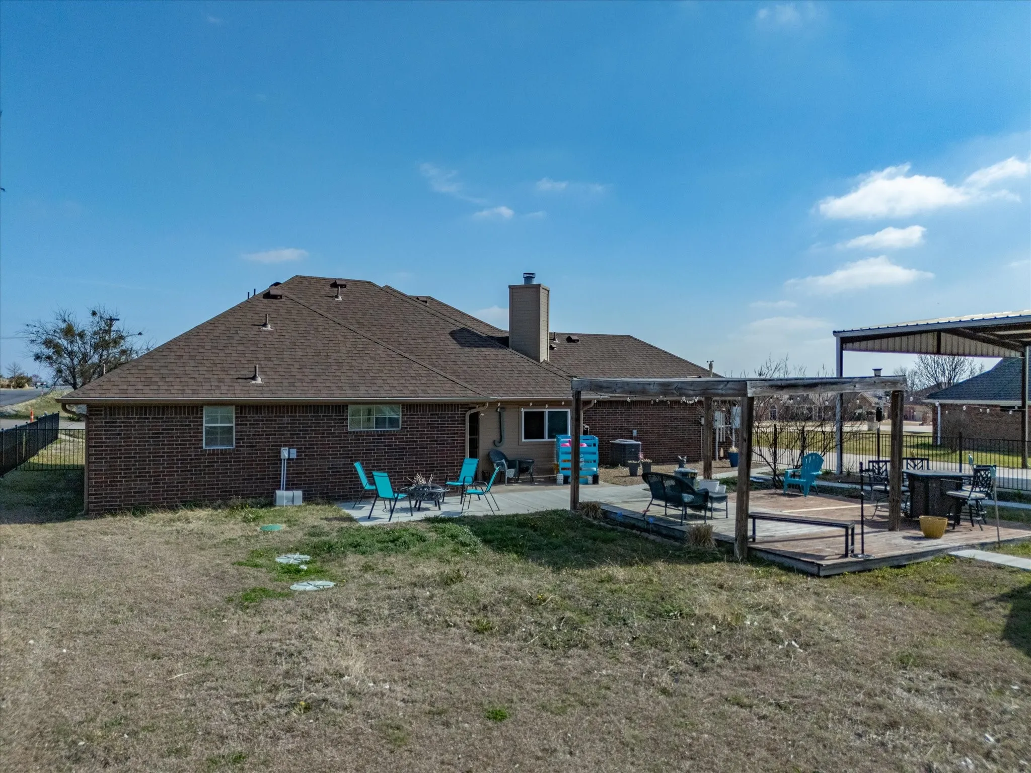Rear view of house with a patio, a pergola, brick siding, and a chimney