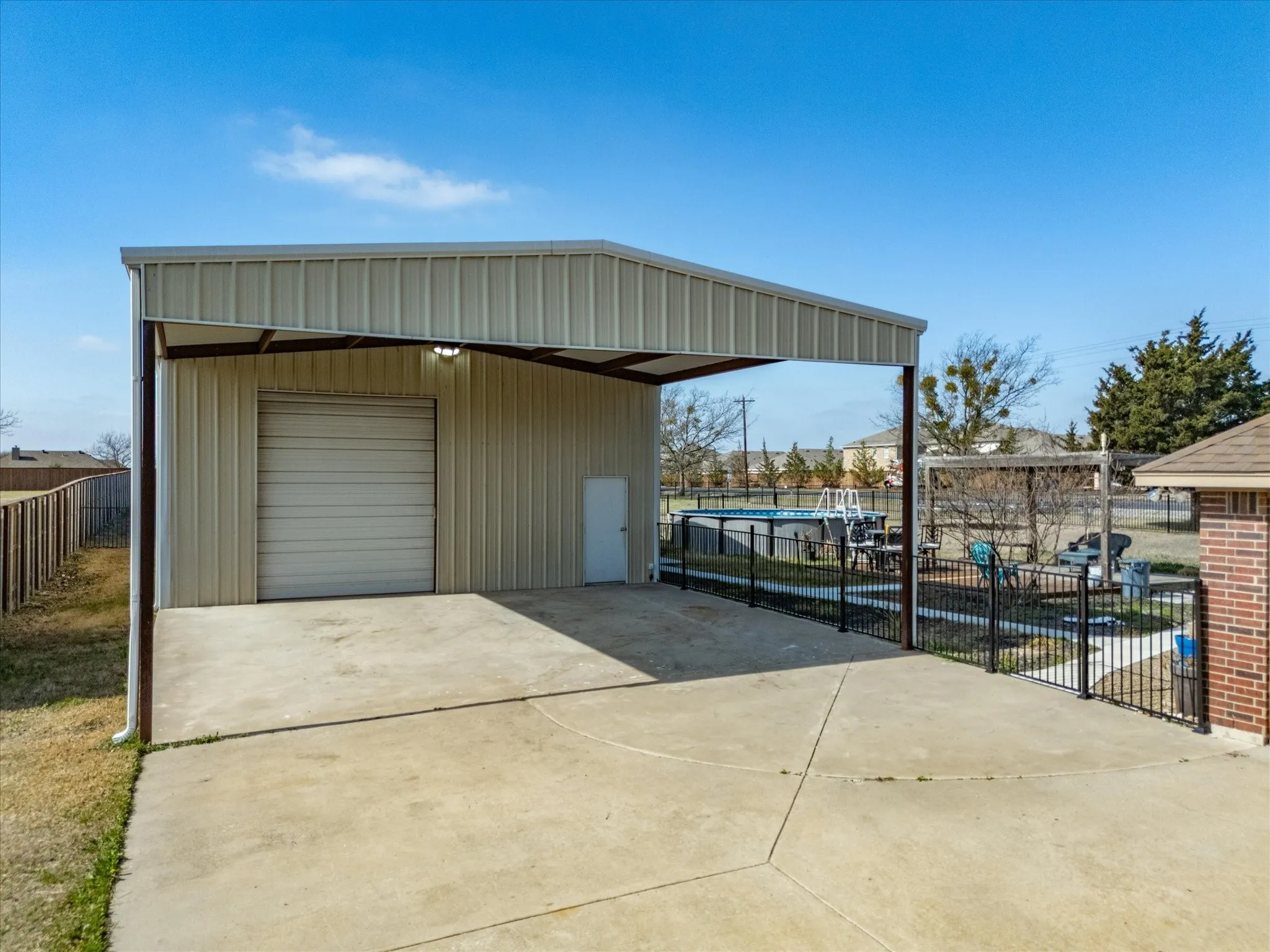 View of outbuilding featuring concrete driveway