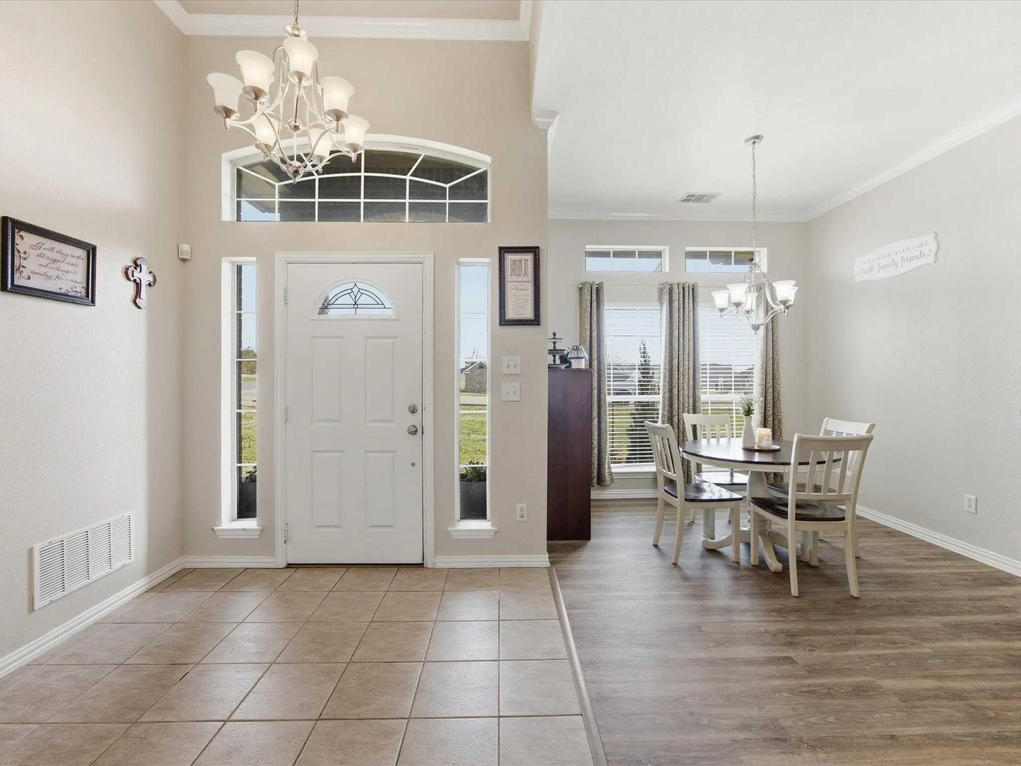 Entryway with suspended lighting, ornamental molding, and light tile patterned floors