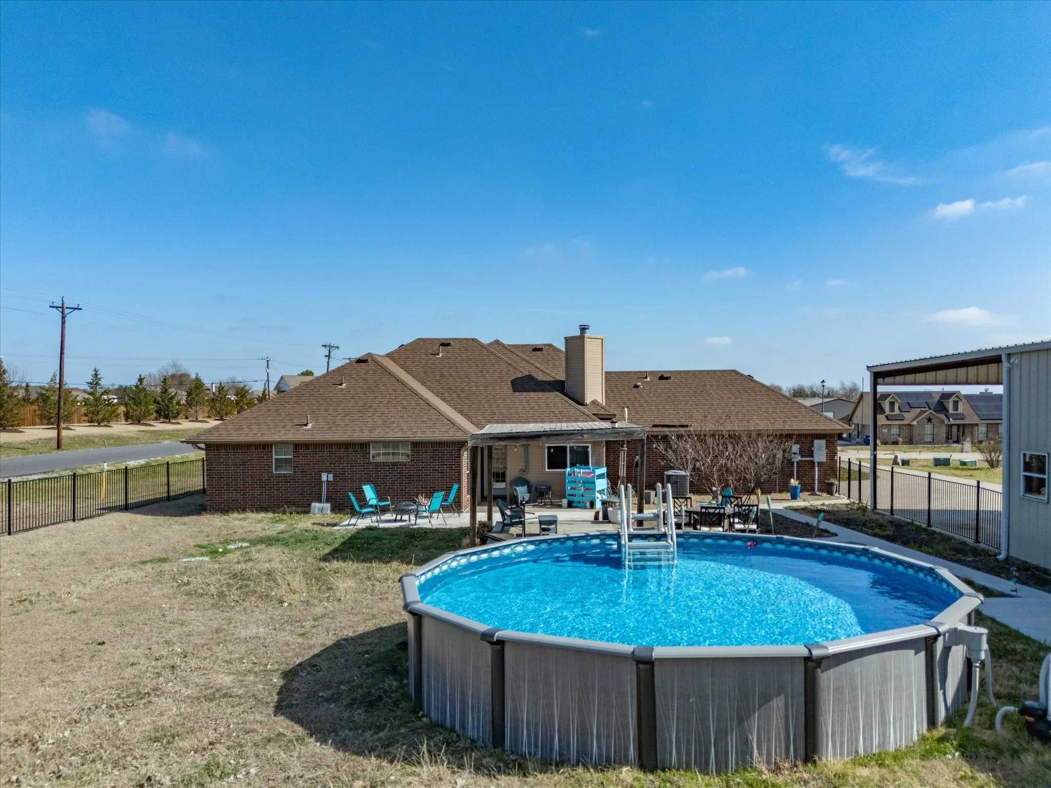 View of pool featuring patio surround and a fenced backyard