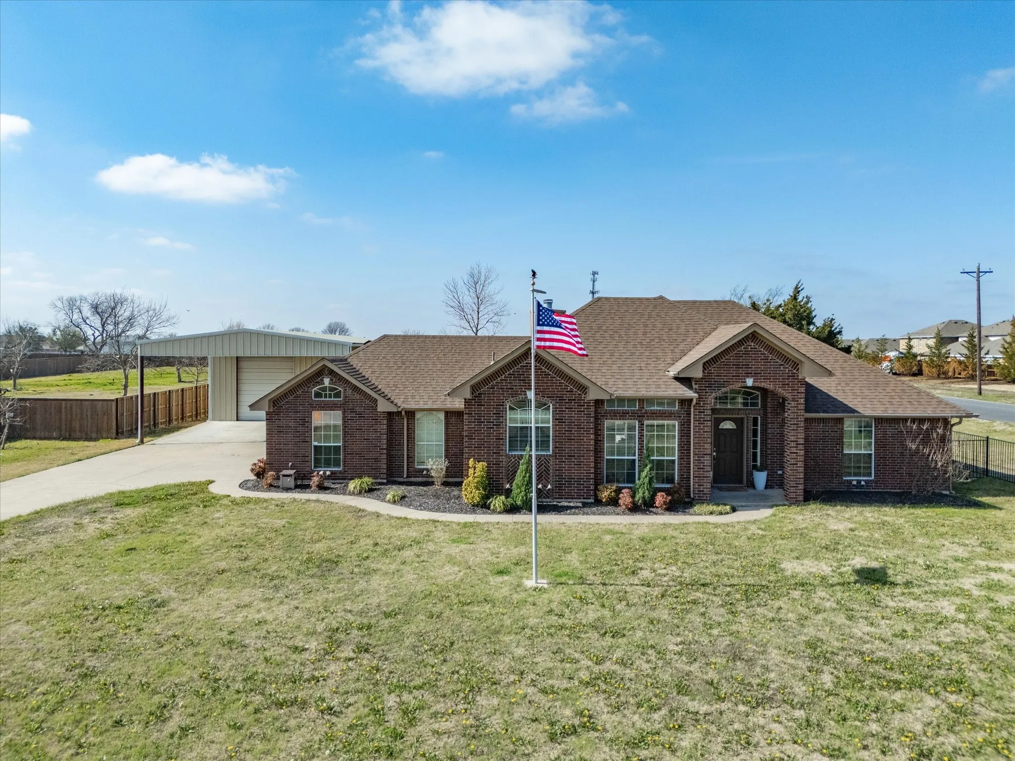 Ranch-style house with roof with shingles, brick siding, and concrete driveway