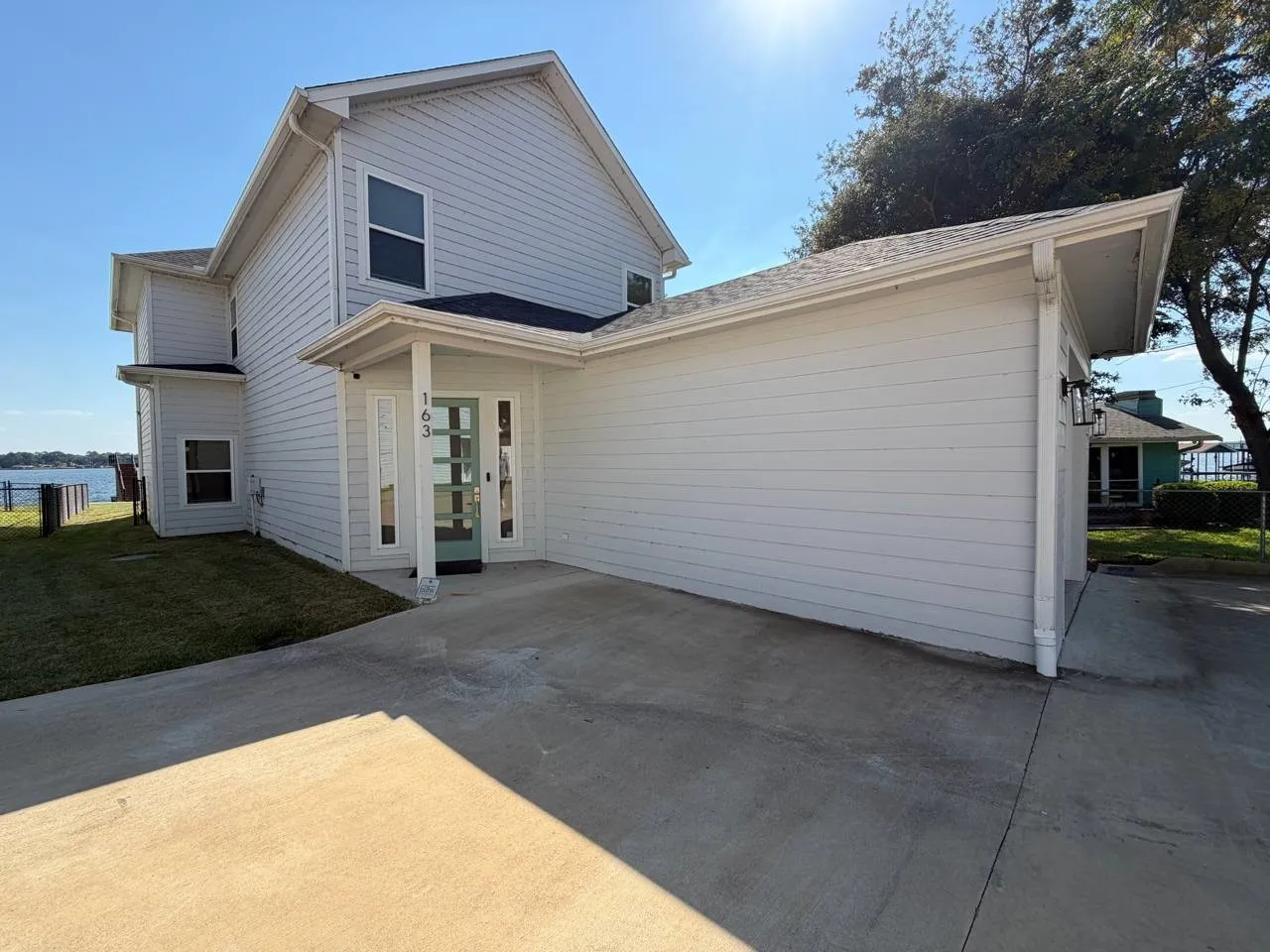 Exterior view showcasing the side of the structure, including the front entry and yard gate.