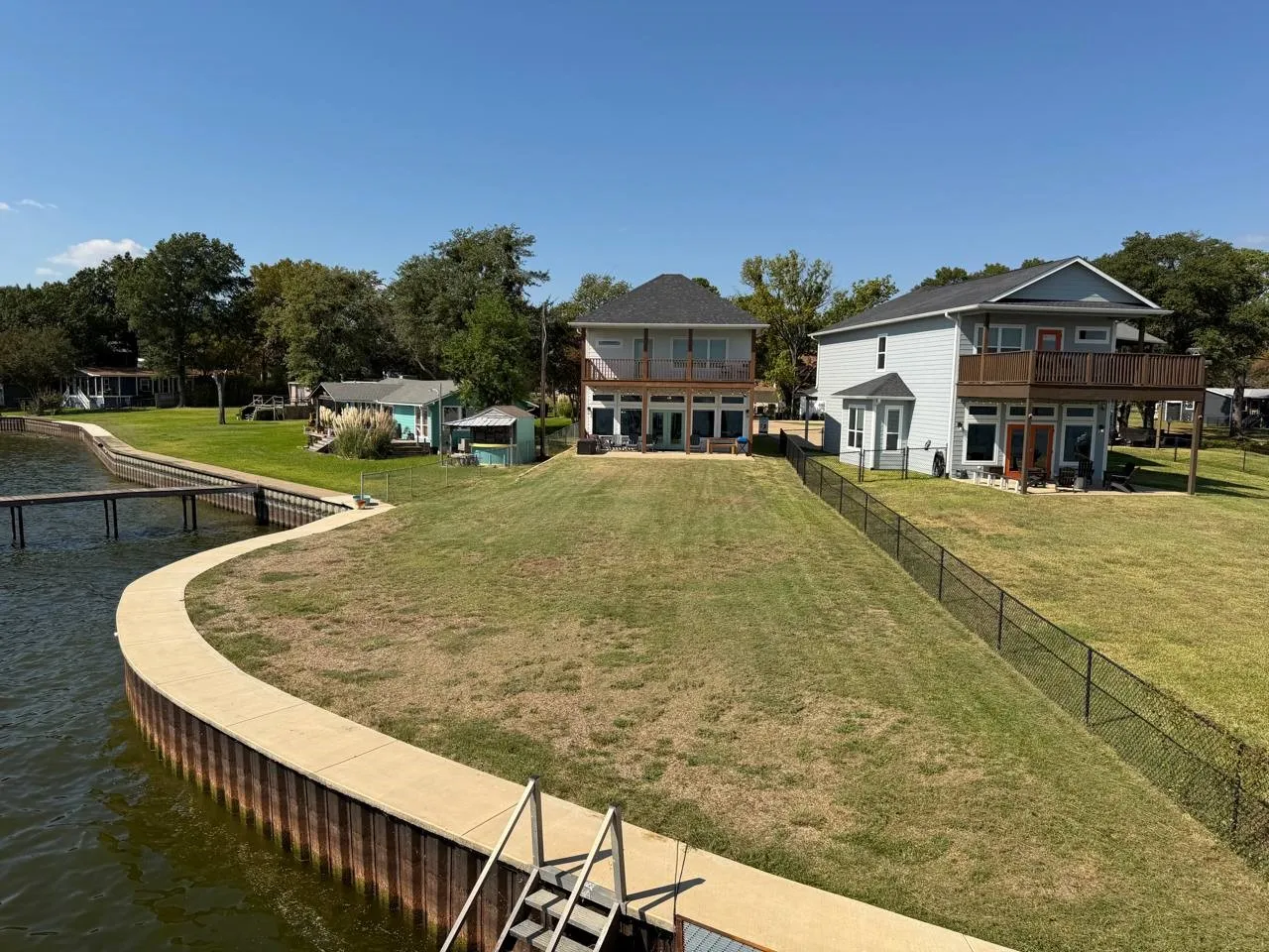 Back of house with a water view, a lawn, and a residential view