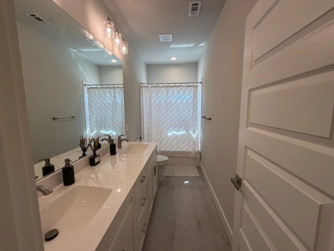 Full bath with double vanity and shower / tub combo with curtain