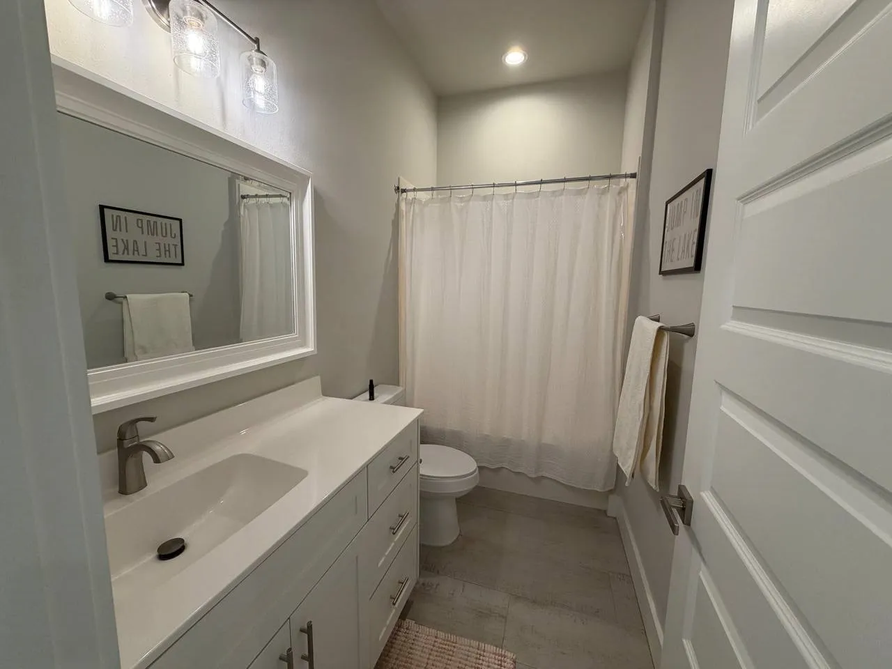 Bathroom featuring vanity, shower / bathtub combination with curtain, and recessed lighting