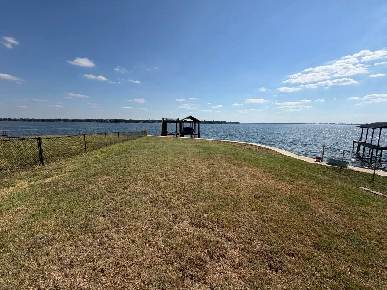 View of yard featuring a water view, a dock, and boat lift