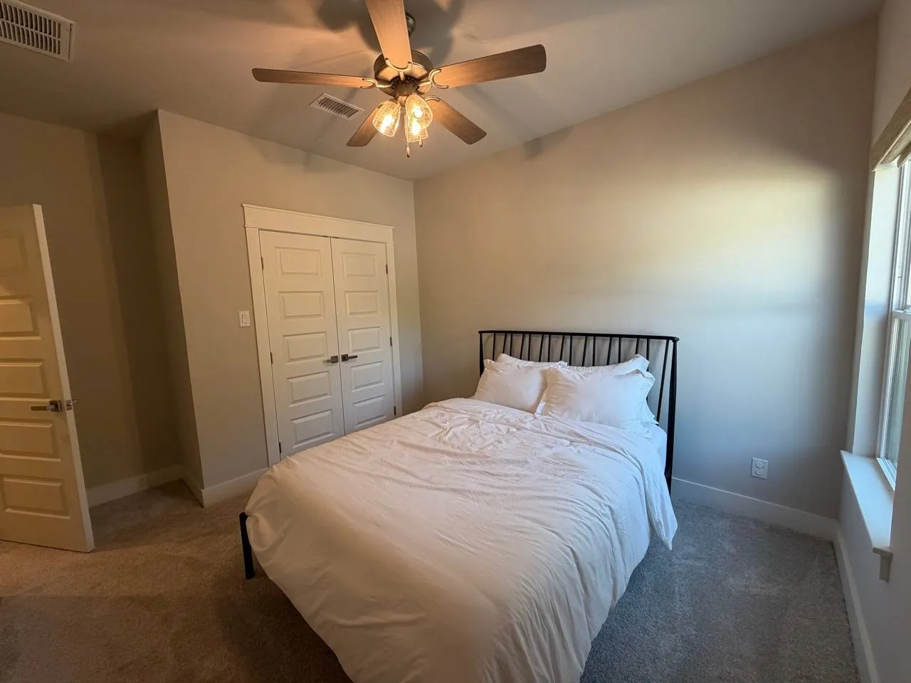Carpeted bedroom featuring a closet and ceiling fan