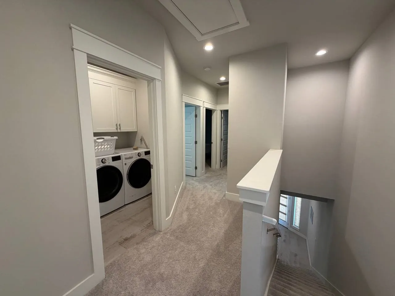 Laundry area with light colored carpet, washing machine and clothes dryer, cabinet space, and recessed lighting