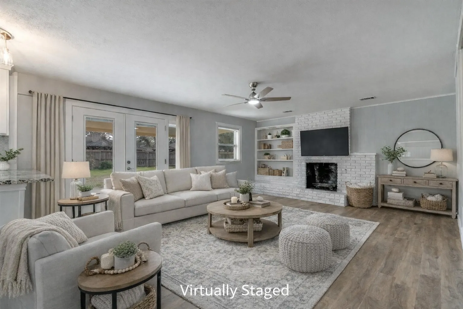 Spacious living room with French doors and wood burning fireplace. Virtual