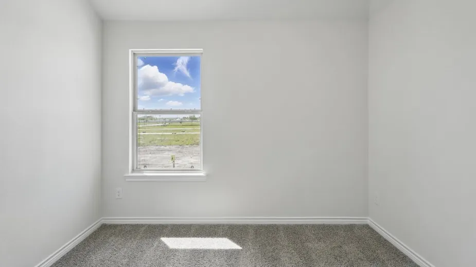 Neutral wall paint finishes a room with gray carpeting and white baseboards