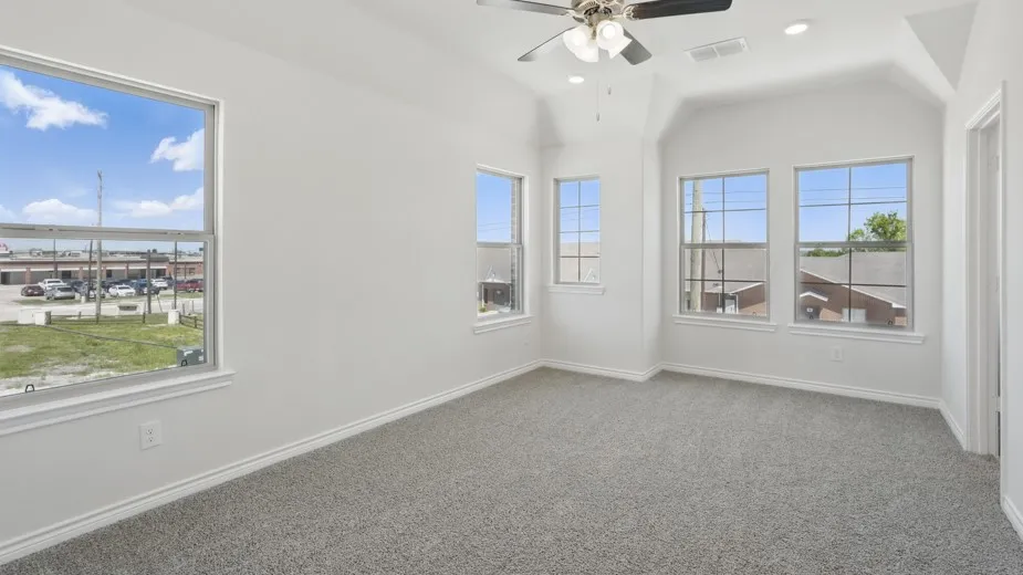 Carpeted room featuring a ceiling fan with light fixture, recessed lighting, and multiple windows with white trim