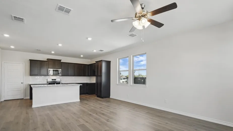 Open-concept living space with wood-finish flooring, a contemporary ceiling fan, and recessed lighting