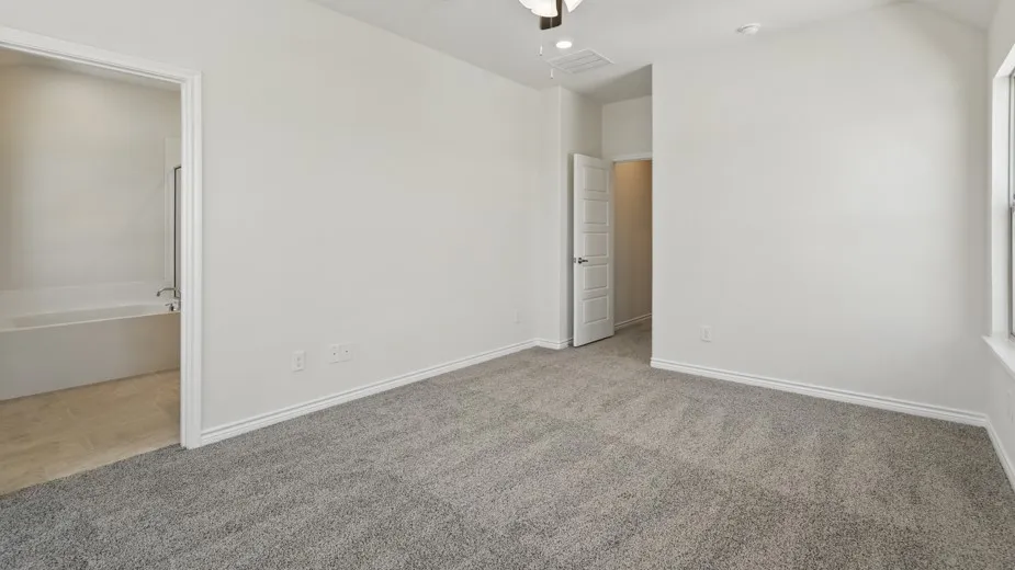 Carpeted interior room featuring a window, white baseboards, and a ceiling fan