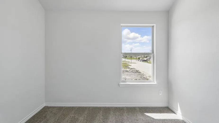 Room featuring a single-hung window with white trim, light gray walls, and textured carpet flooring