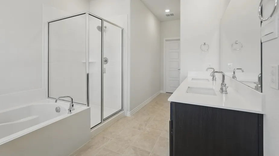 Bathroom featuring a glass-enclosed shower, a built-in bathtub with chrome fixtures, a double vanity with undermount sinks and white countertops, and light-toned tile flooring