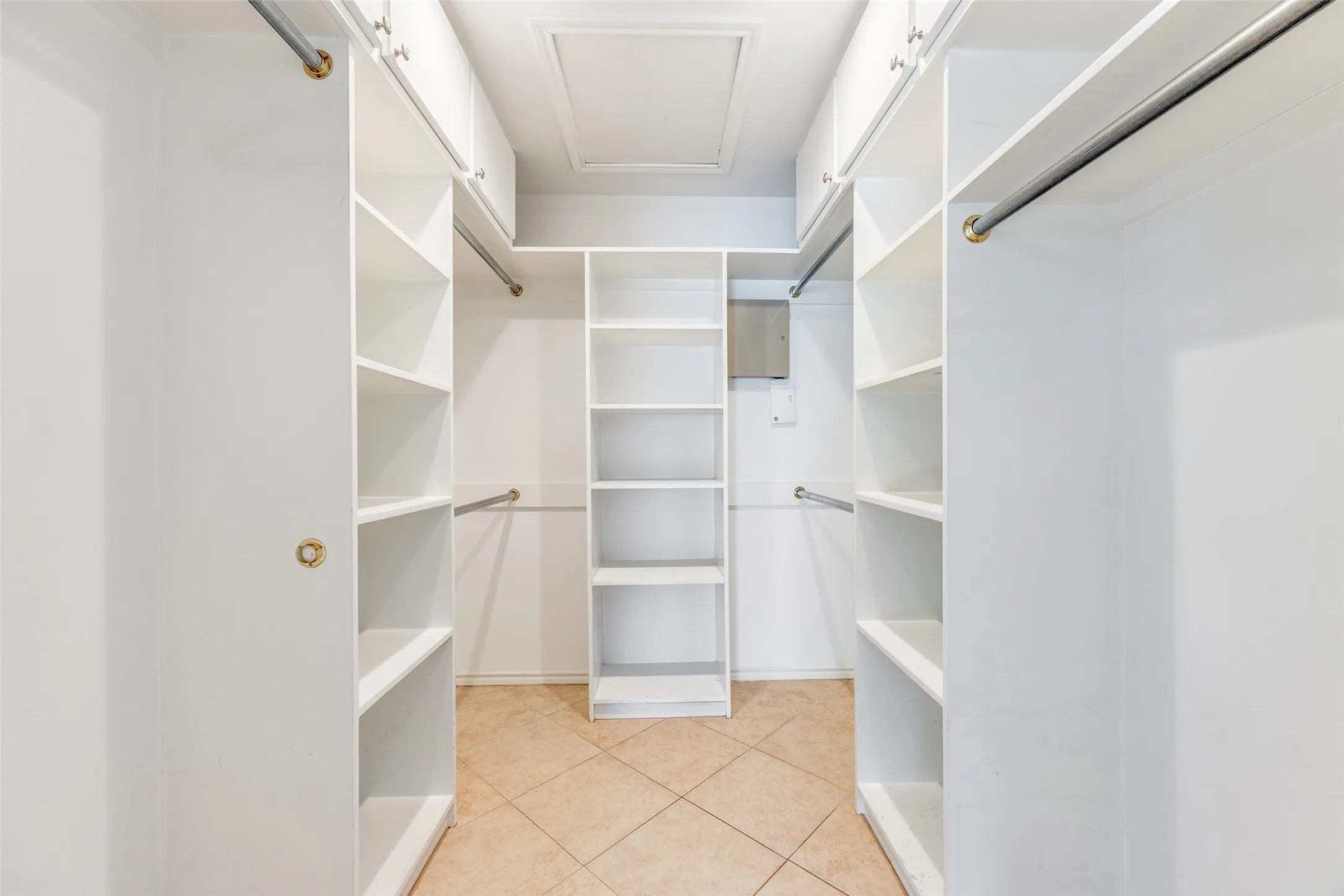 Walk in closet featuring light tile patterned flooring and attic access