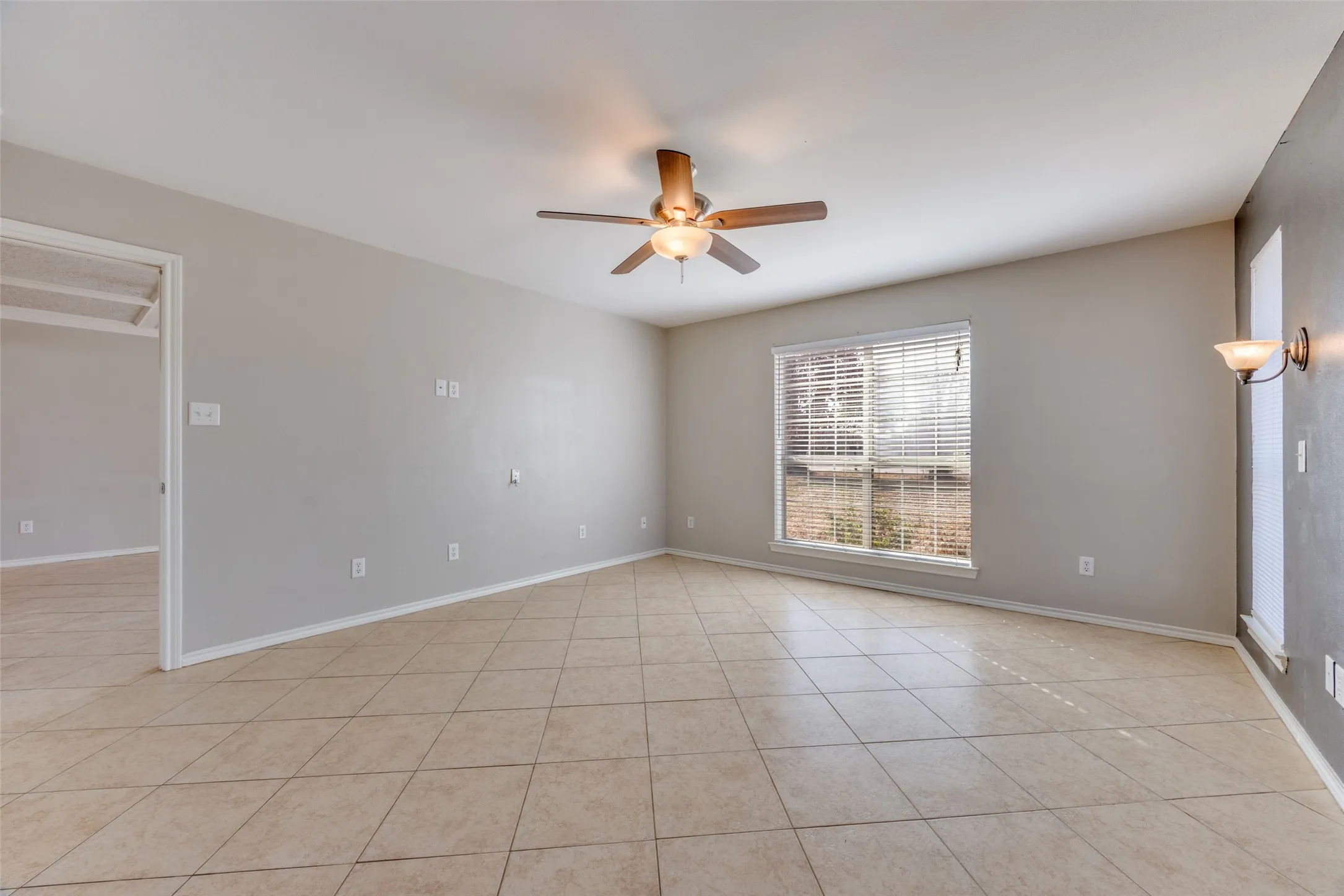 Unfurnished room featuring ceiling fan and light tile patterned flooring