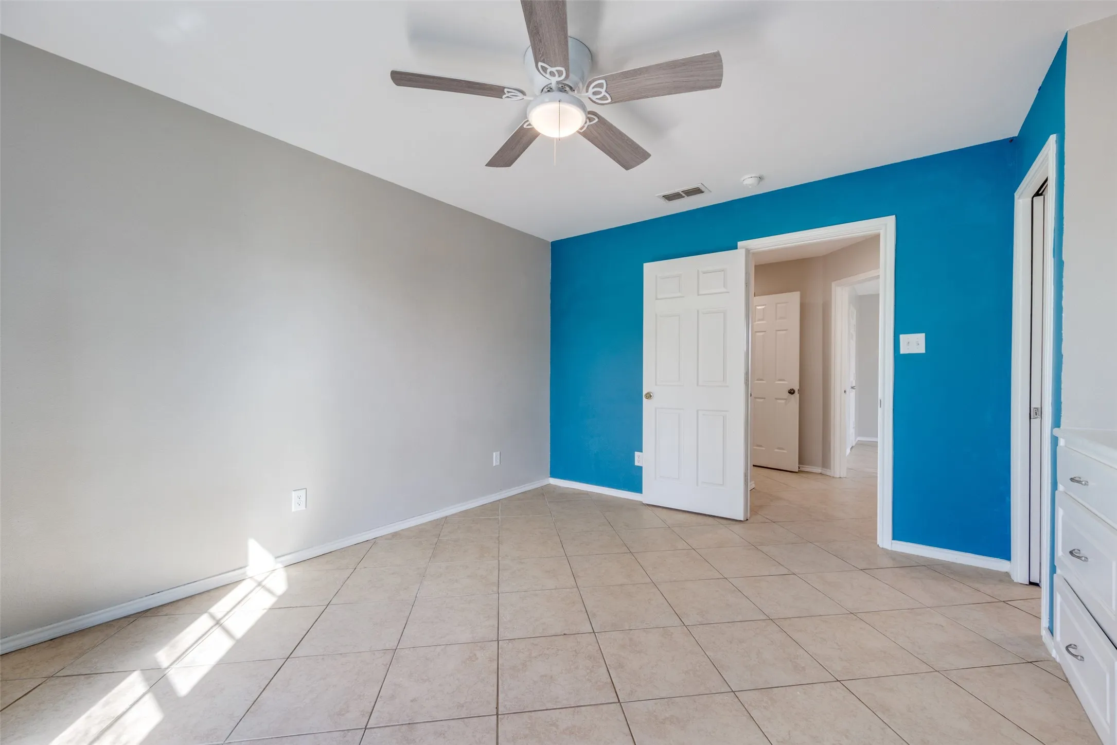 Unfurnished bedroom with ceiling fan and light tile patterned floors