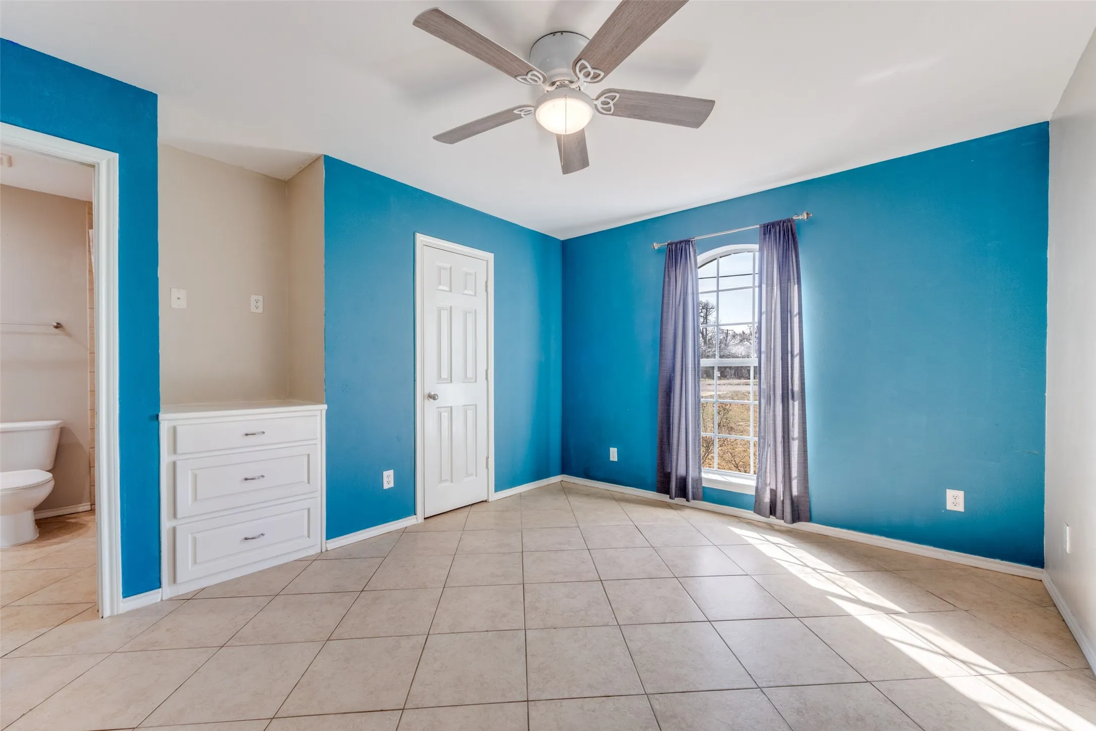 Unfurnished bedroom featuring ceiling fan and light tile patterned floors