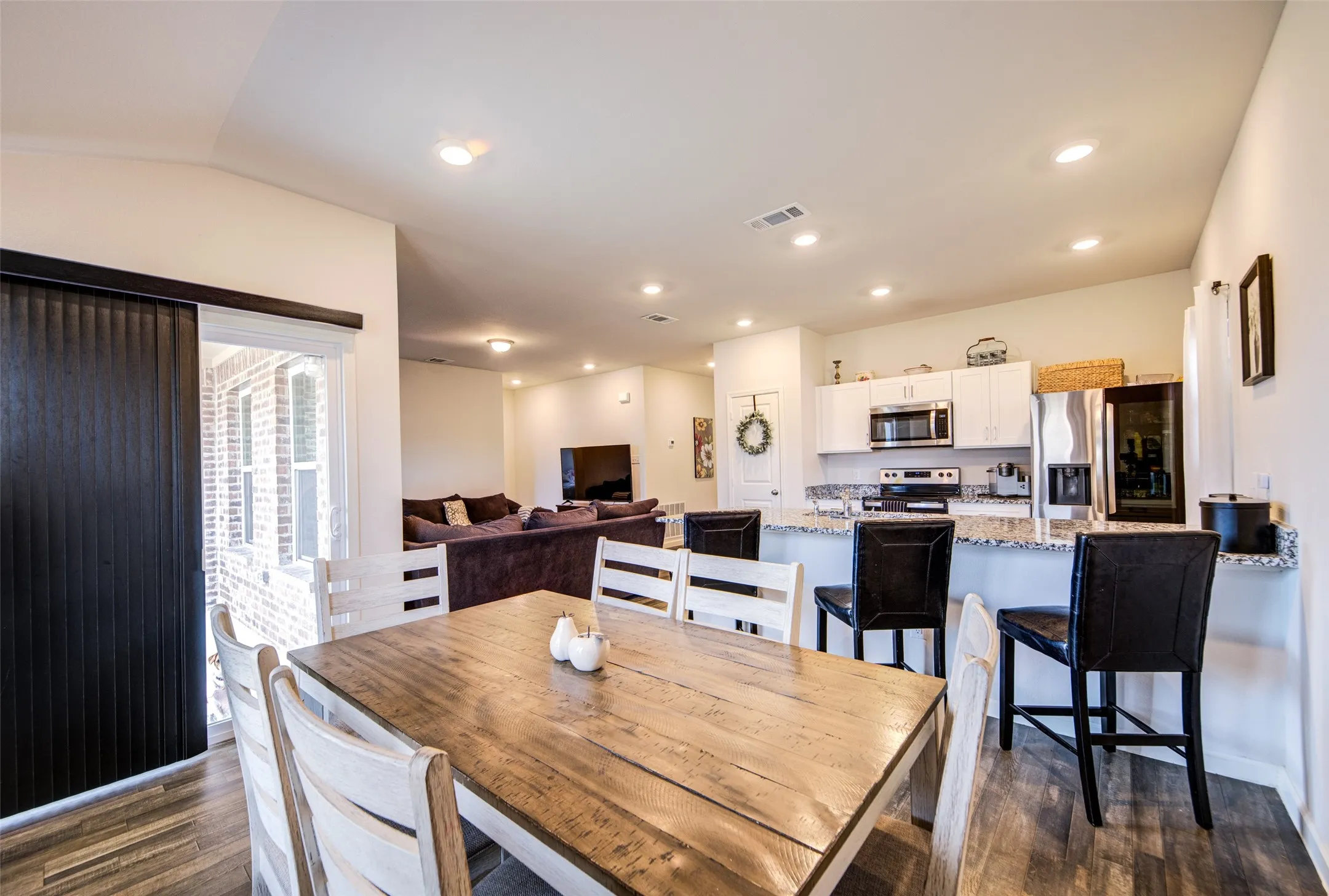 Dining room with dark wood finished floors and recessed lighting