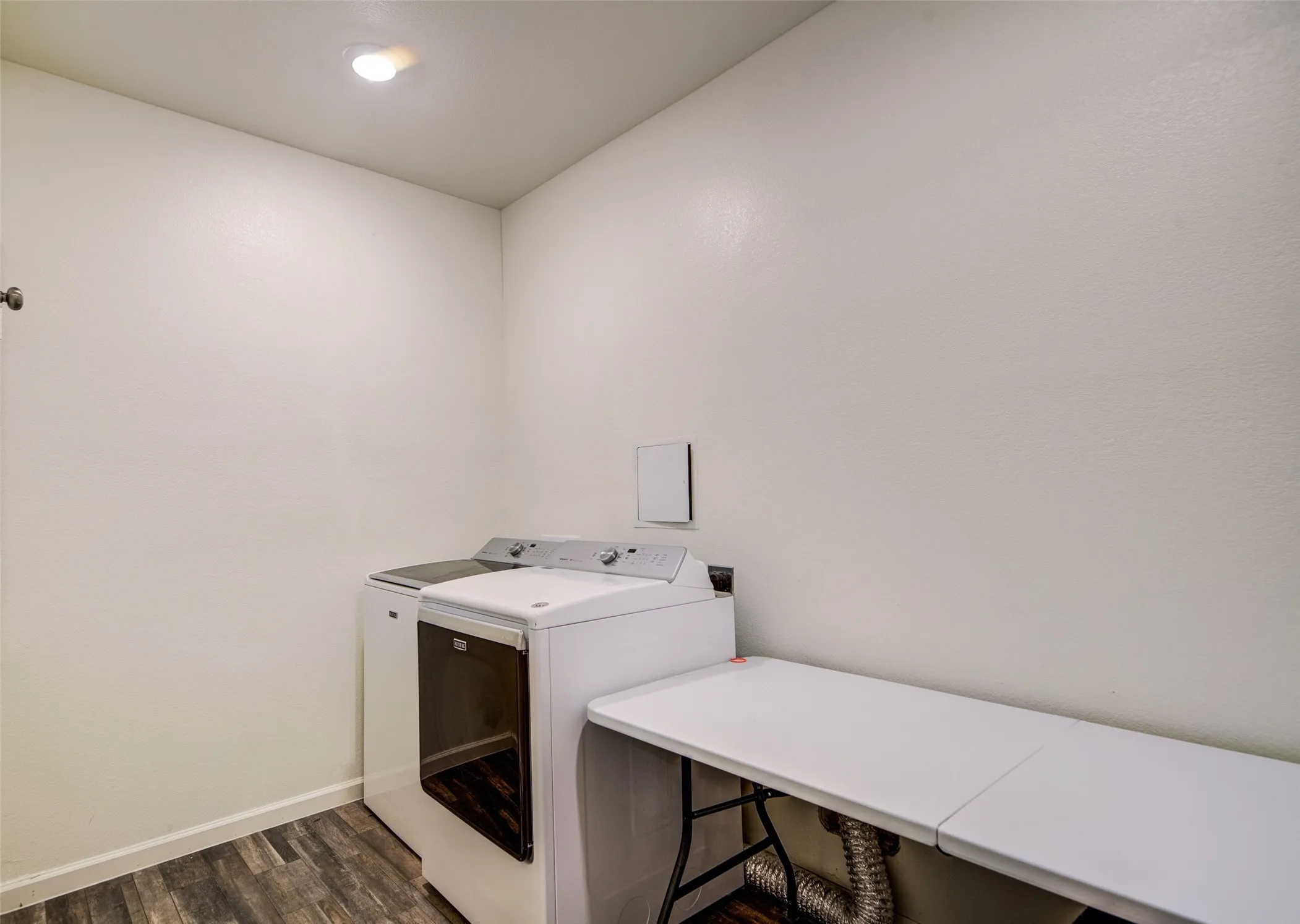 Laundry area featuring dark wood-style floors and separate washer and dryer