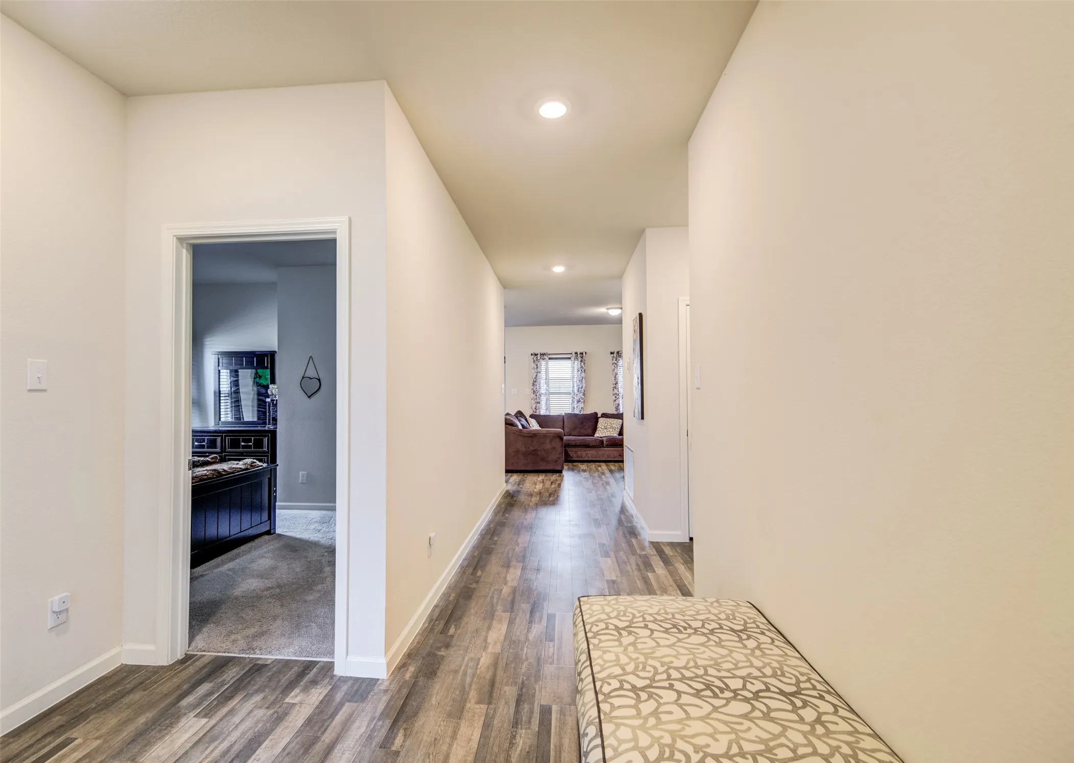 Hallway with dark wood-style flooring and recessed lighting