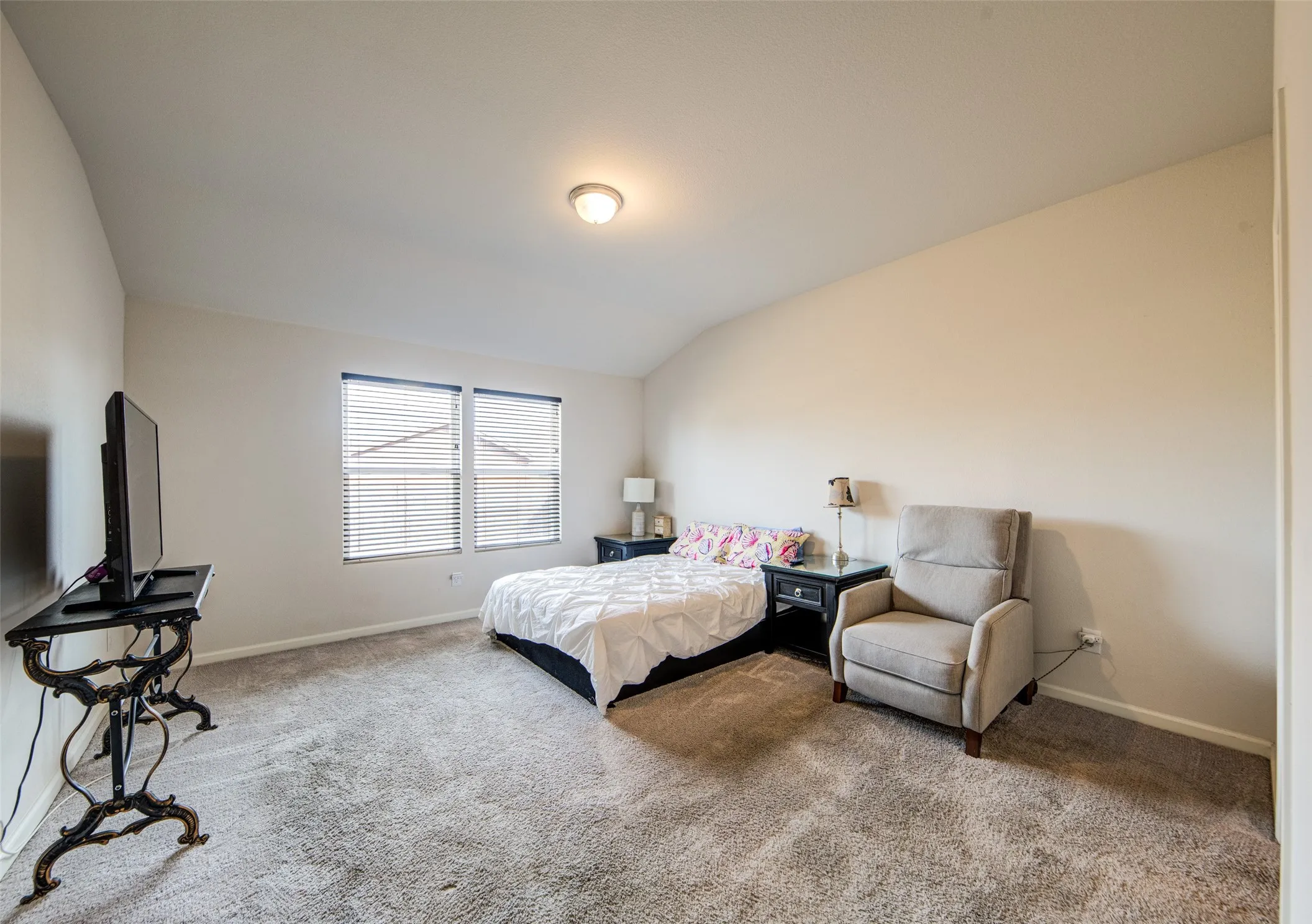 Bedroom with carpet flooring and vaulted ceiling