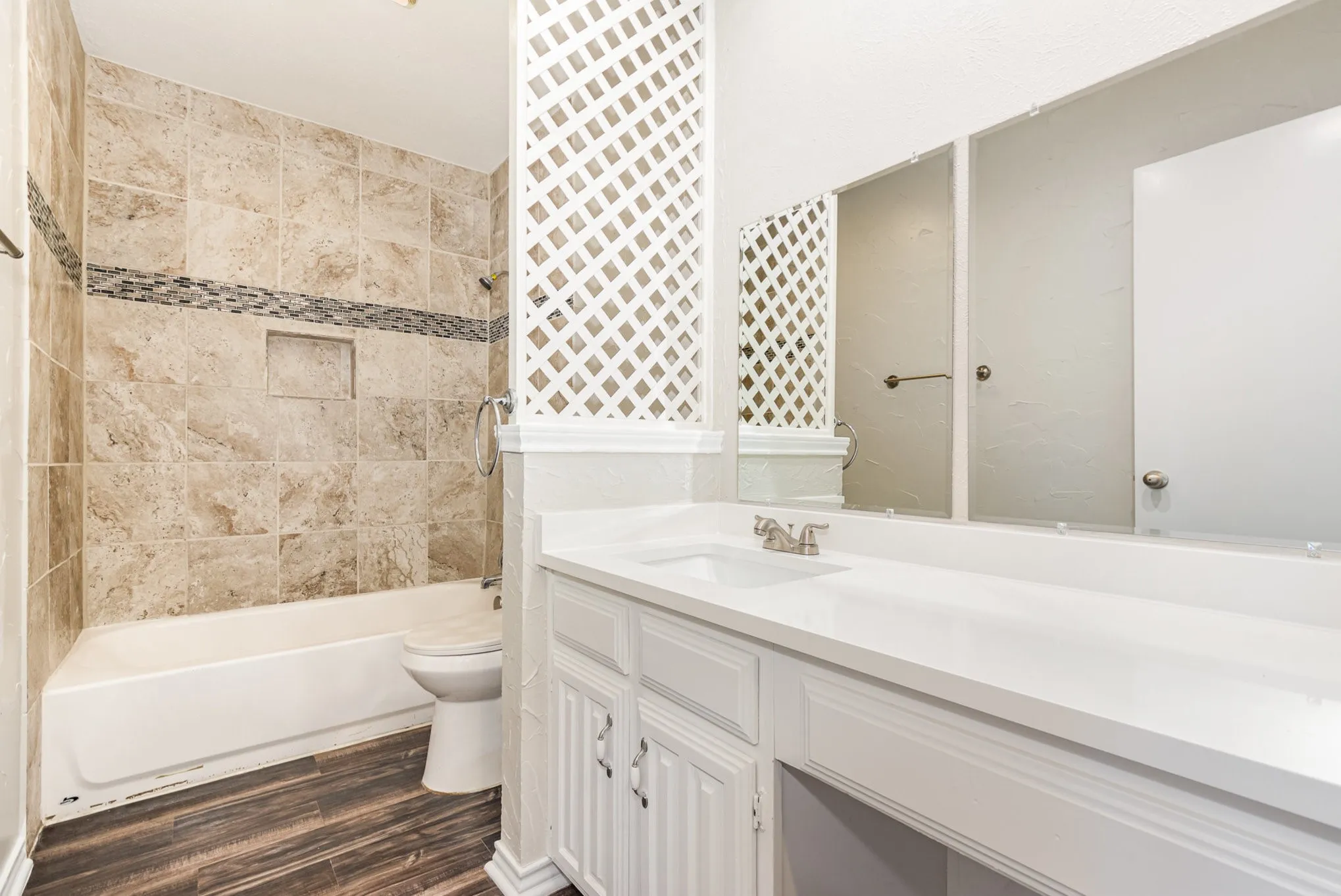 Bathroom featuring vanity, shower / tub combination, and wood finished floors