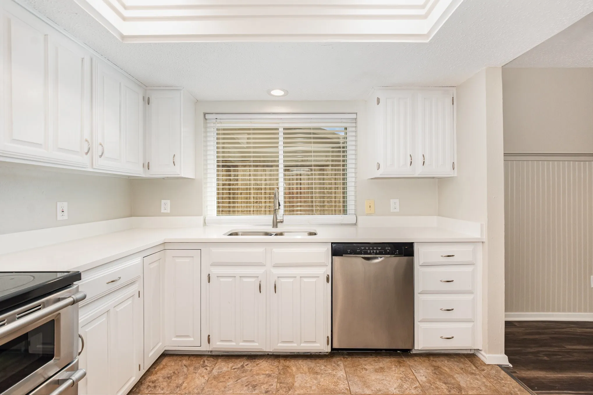 Kitchen featuring appliances with stainless steel finishes, white cabinets, recessed lighting, light countertops, and a textured ceiling