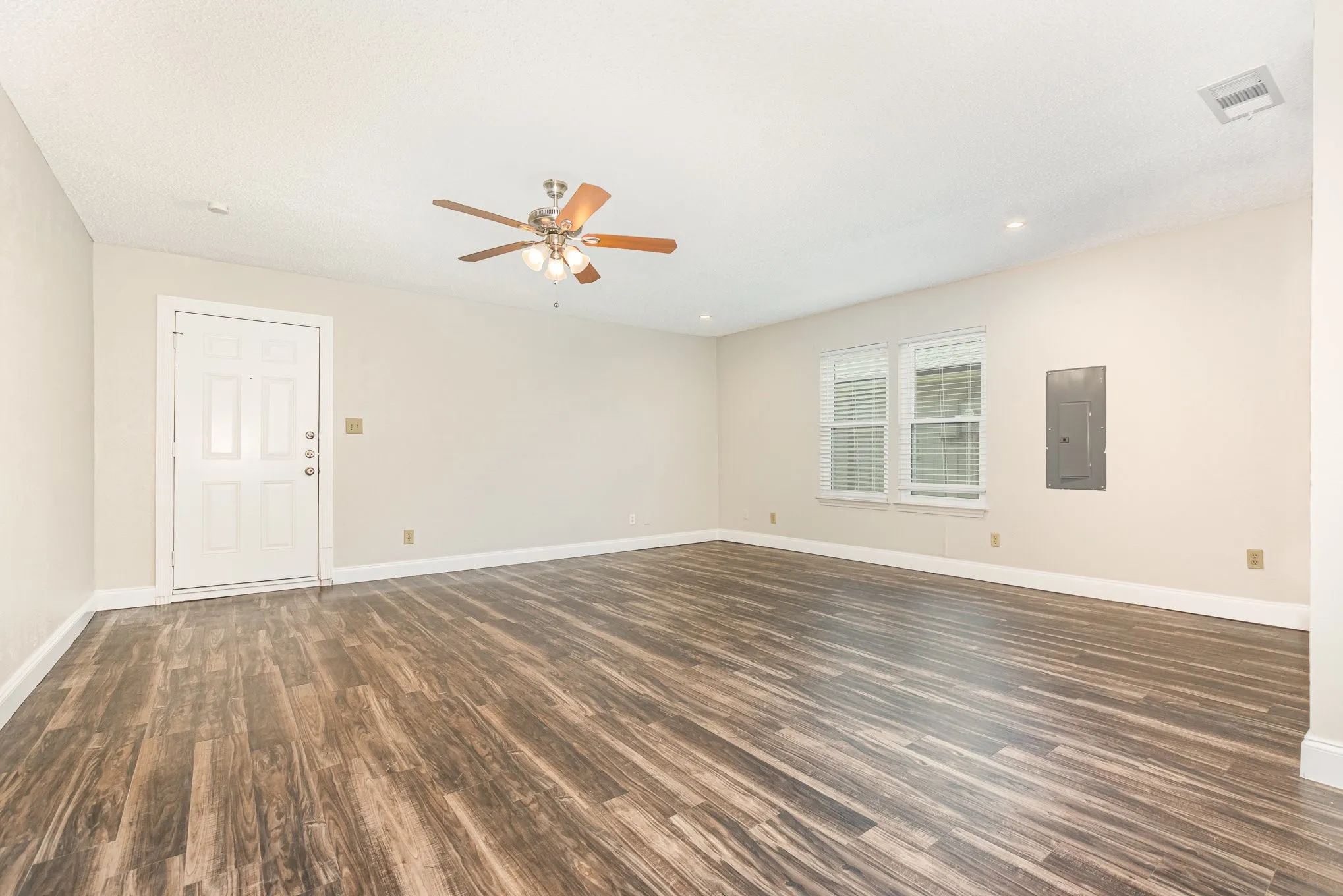 Spare room featuring a ceiling fan, dark wood-type flooring, electric panel, and recessed lighting
