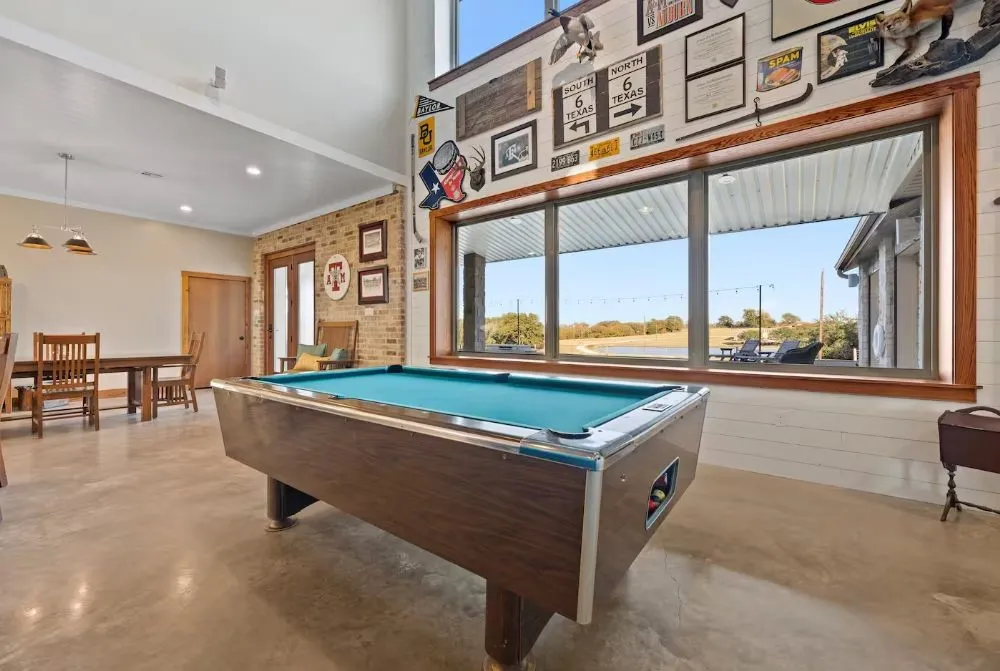 Game room featuring plenty of natural light, pool table, finished concrete flooring, crown molding, and a towering ceiling