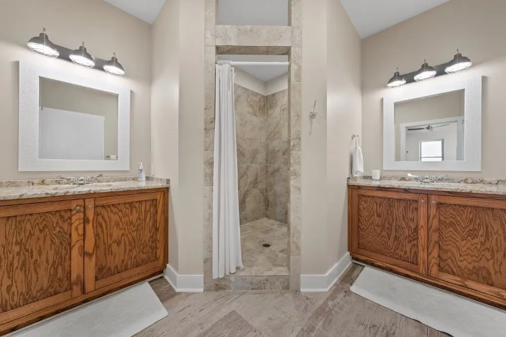 Bathroom with vanity, a shower stall, and two sinks