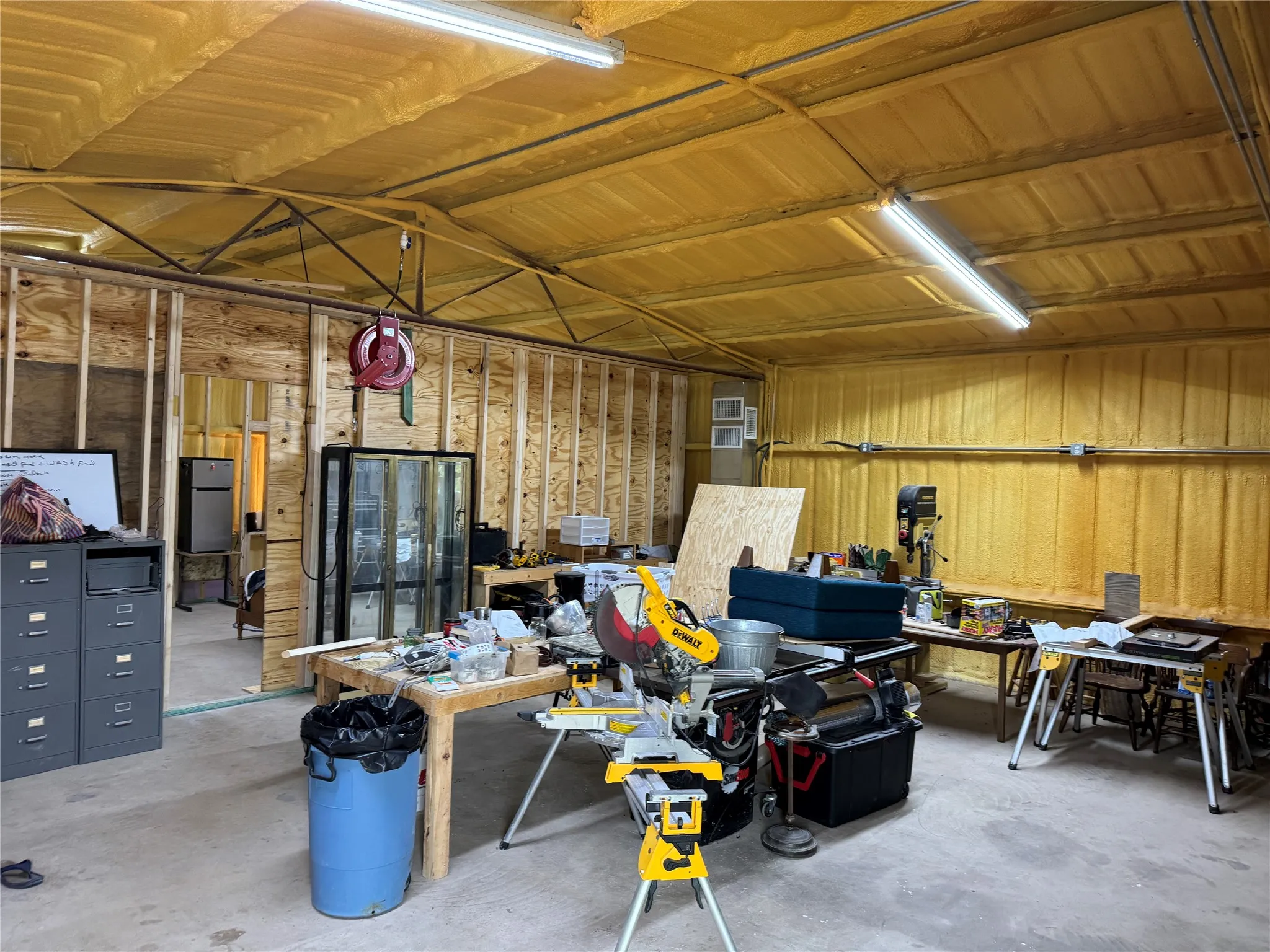 Garage with a workshop area and fridge