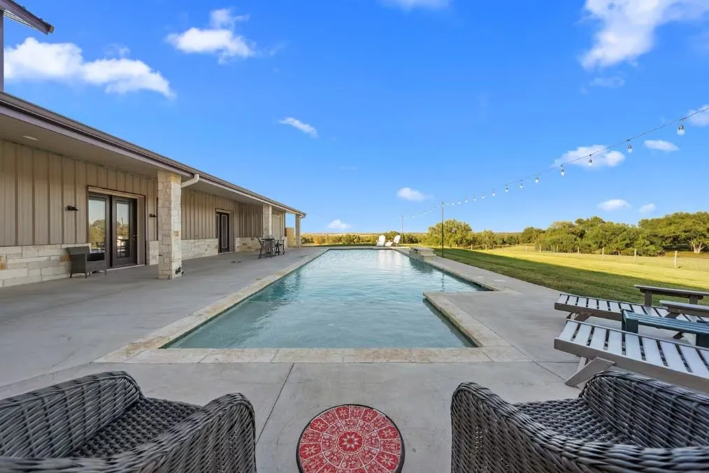 Swimming pool with a patio and a yard