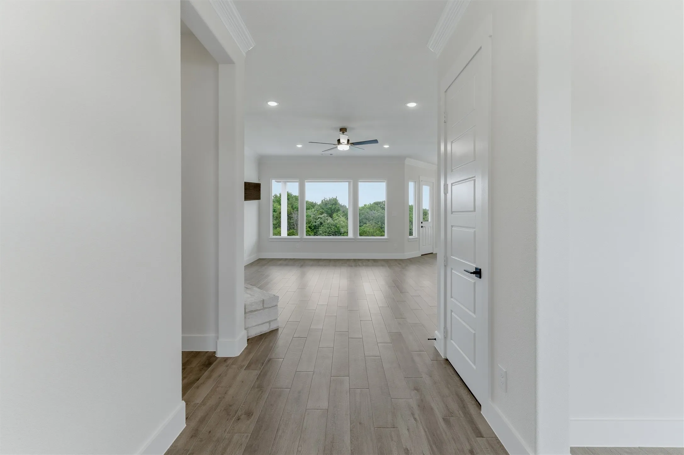 Spacious interior featuring wood-finish flooring, recessed lighting, and a contemporary ceiling fan