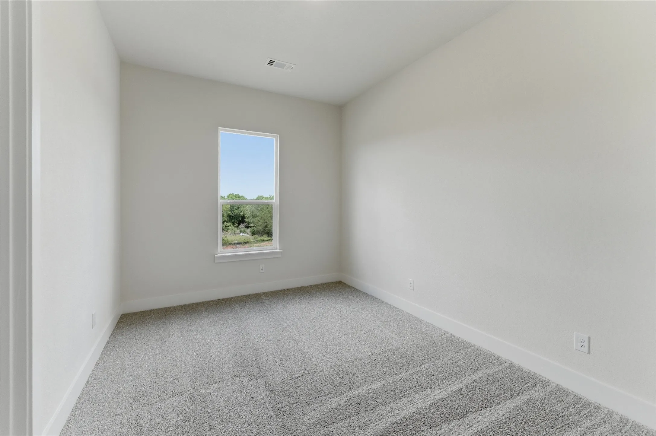 Neutral tone walls with a single window providing natural light
