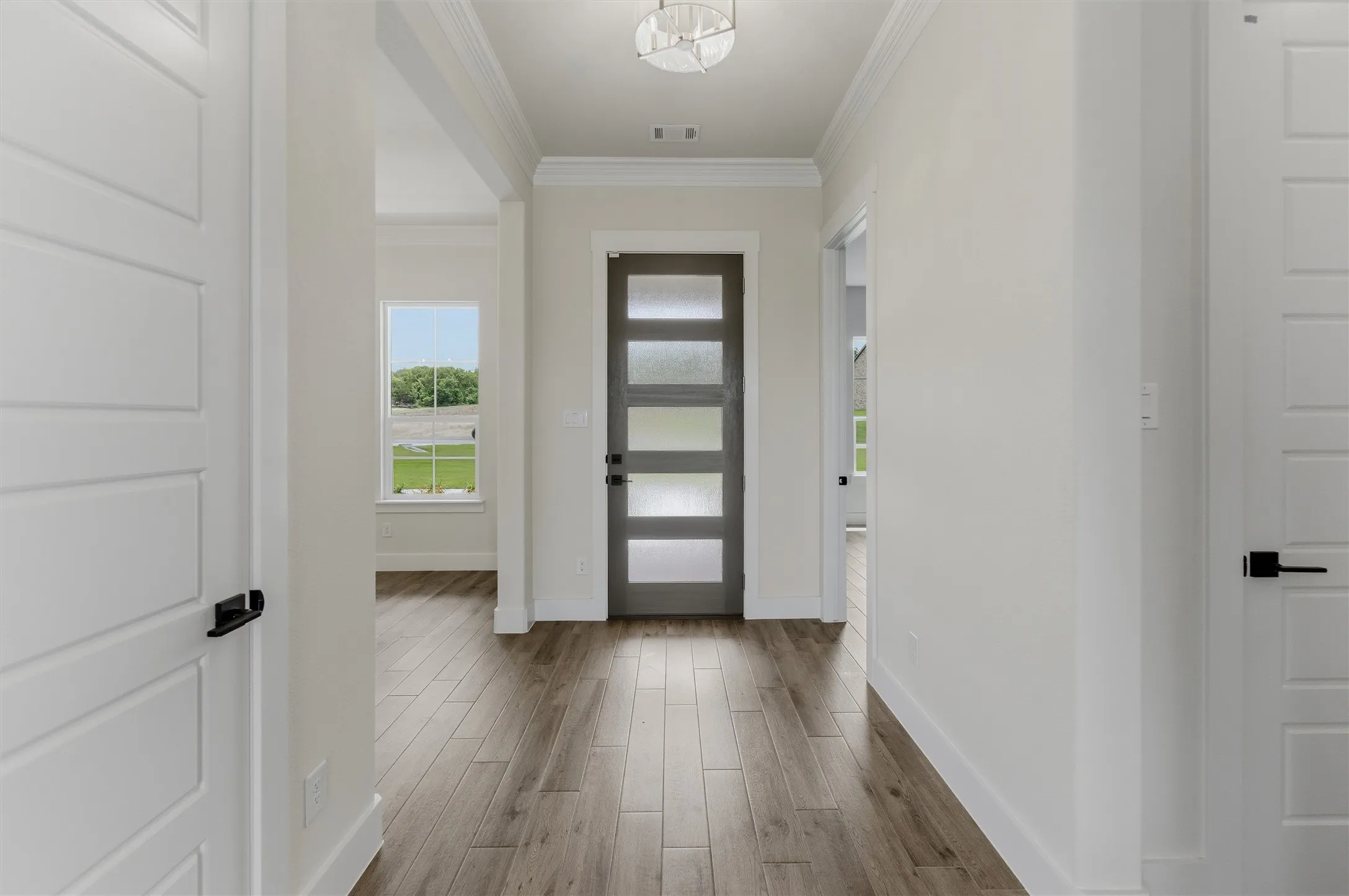 Entryway featuring wood-finish flooring, a modern glass-paneled entry door, and recessed lighting