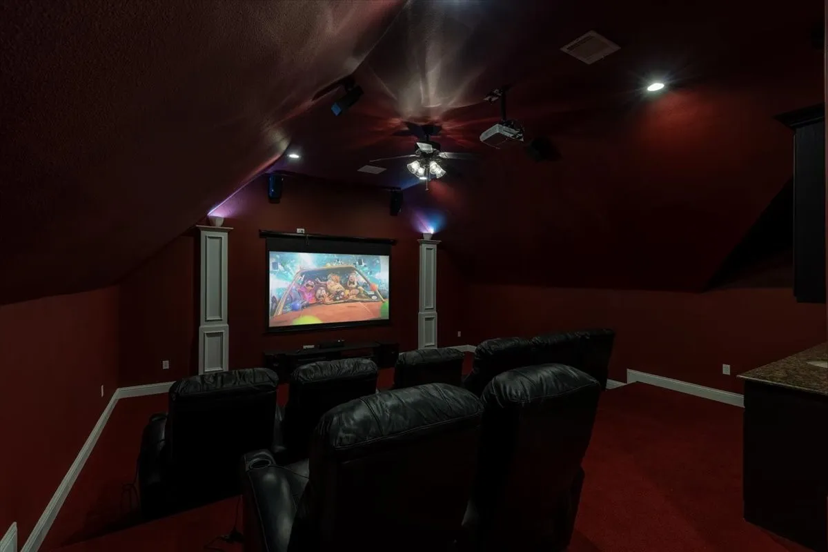 Cinema with a ceiling fan and dark carpet