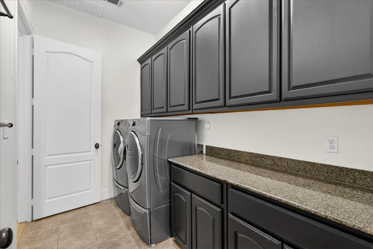 Laundry area with separate washer and dryer and cabinet space