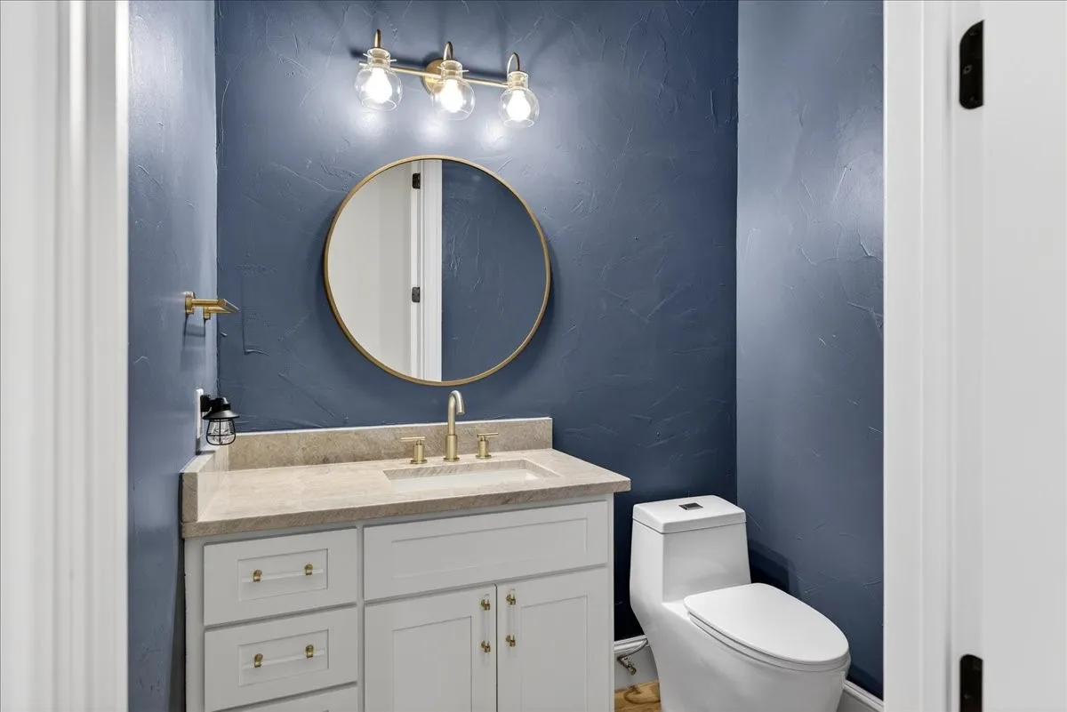 Half bathroom with a textured wall and vanity