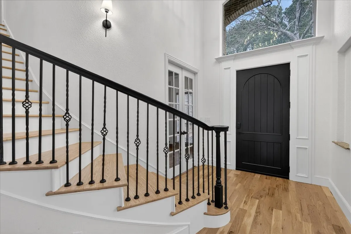 Entryway with wood finished floors and a high ceiling