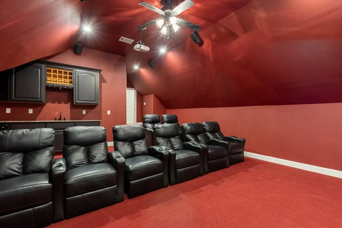 Cinema with dark carpet and baseboards