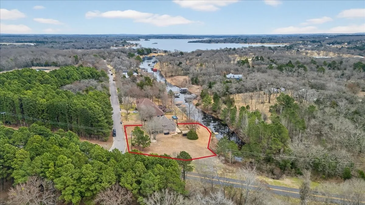 Aerial view of property and surrounding area with a heavily wooded area and property boundaries highlighted