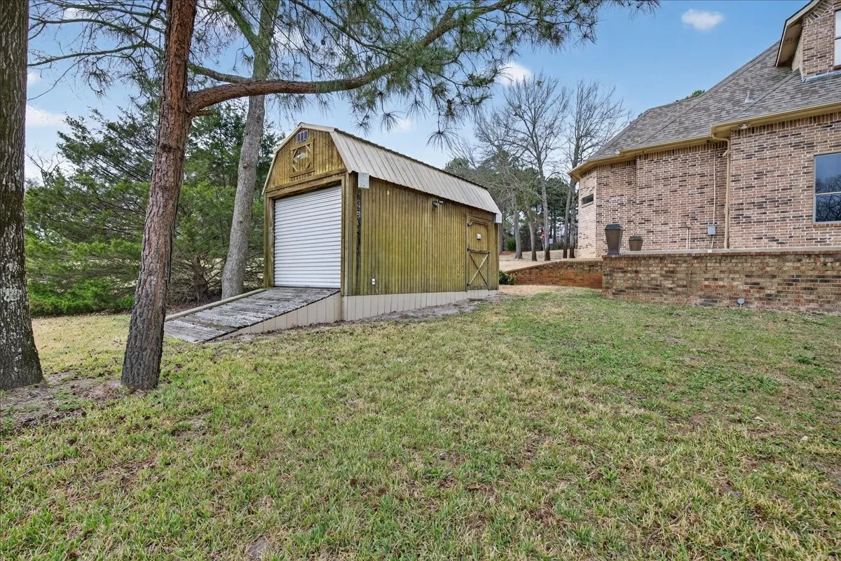 View of grassy yard featuring an outbuilding