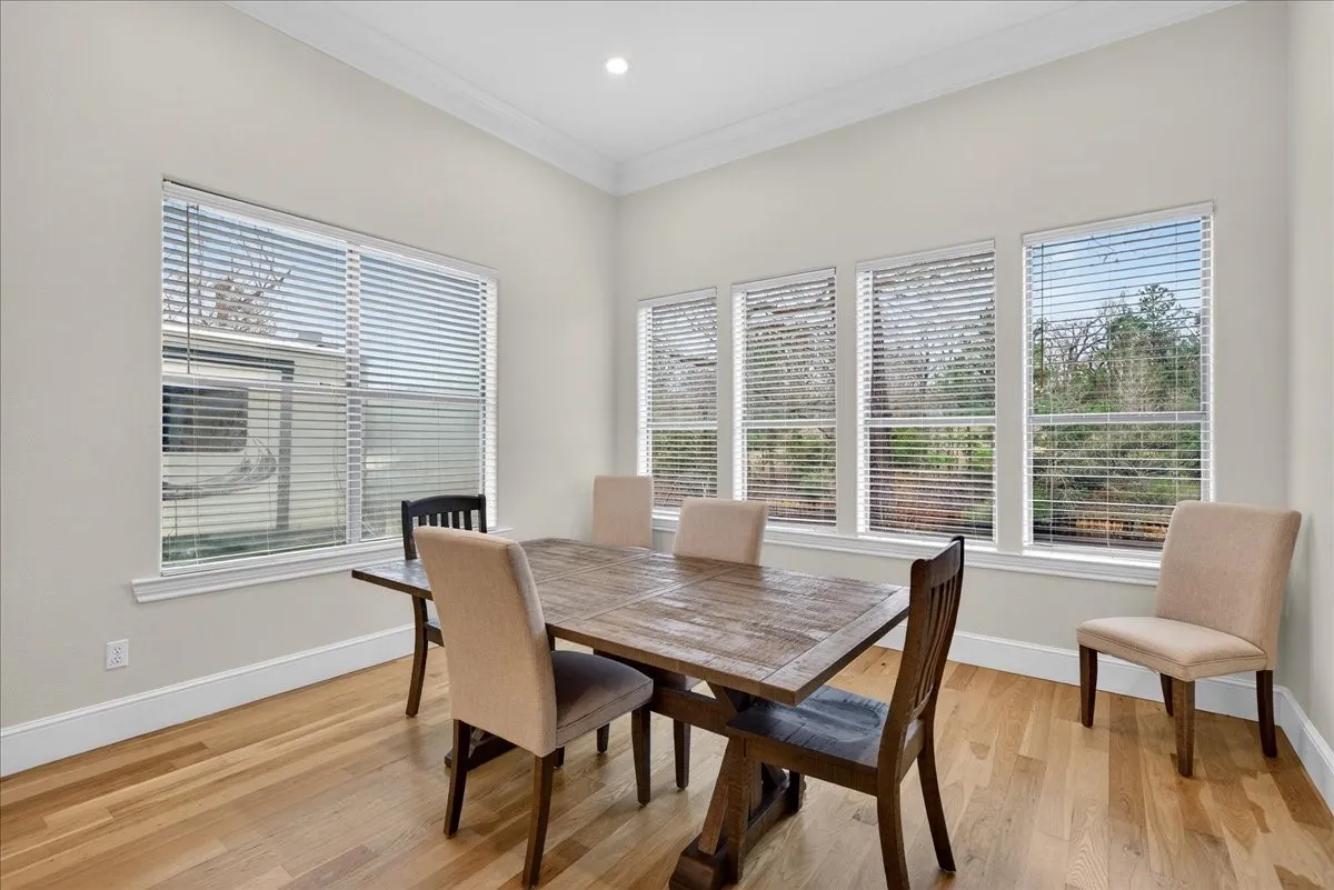 Dining area with light wood-style floors, crown molding, plenty of natural light, and recessed lighting
