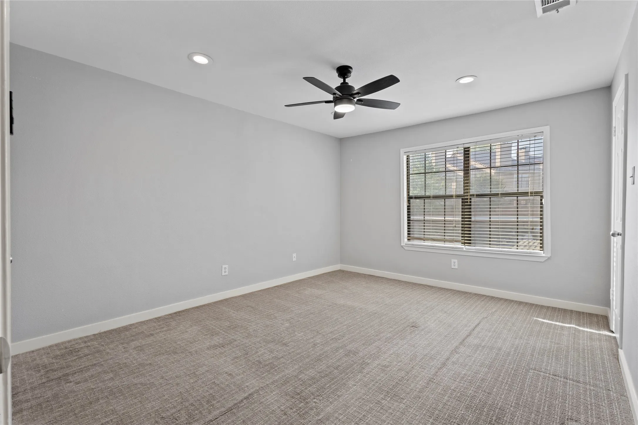 Carpeted spare room with ceiling fan