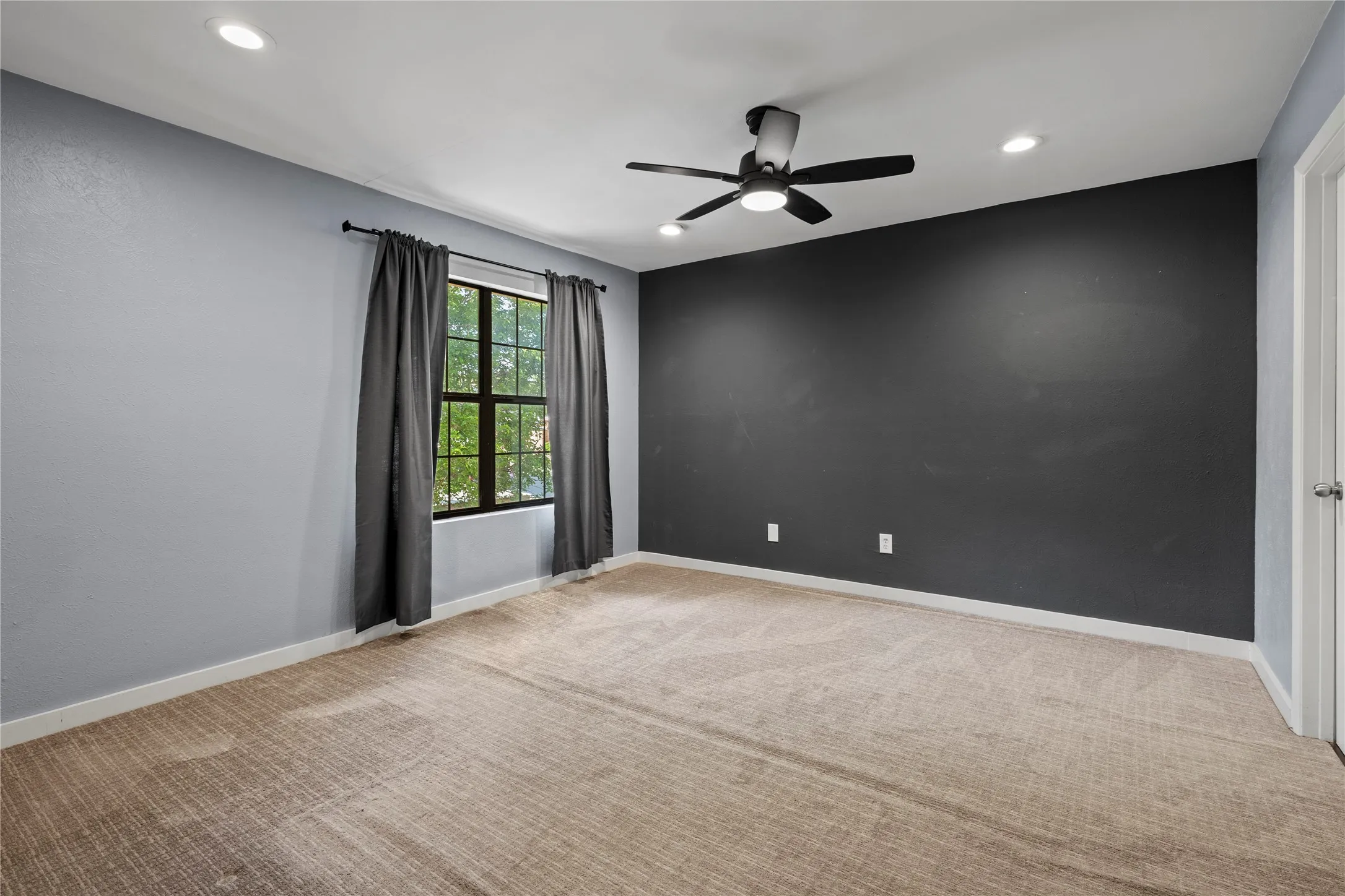 Empty room featuring light carpet and ceiling fan