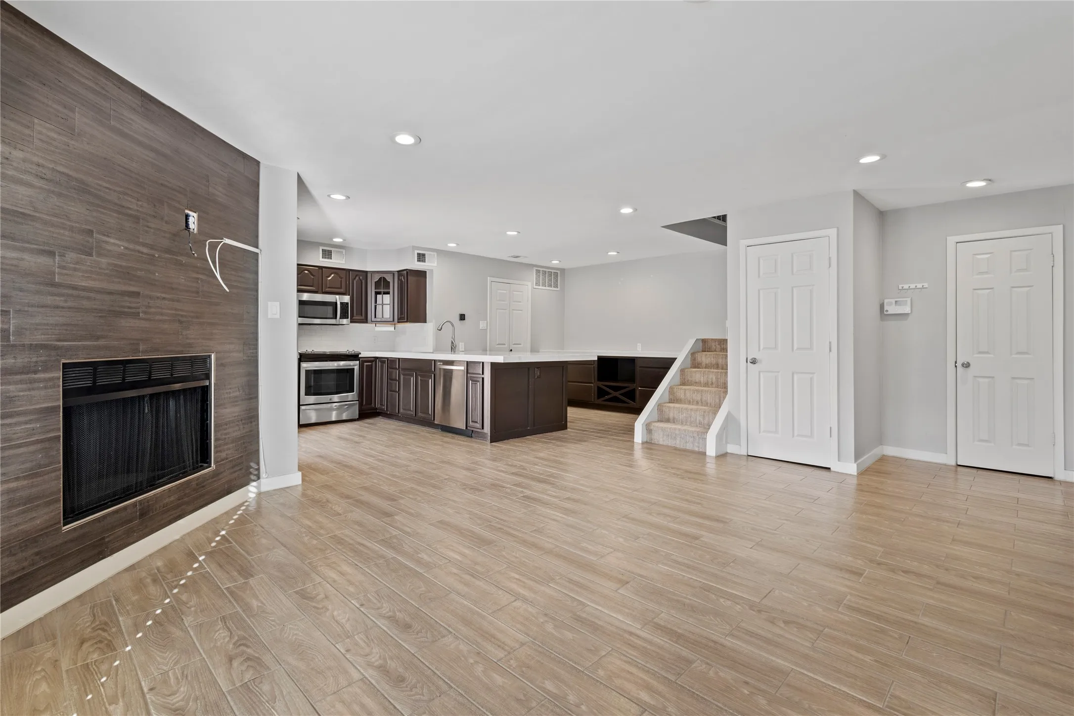 Kitchen featuring light hardwood / wood-style flooring, dark brown cabinetry, sink, and stainless steel appliances